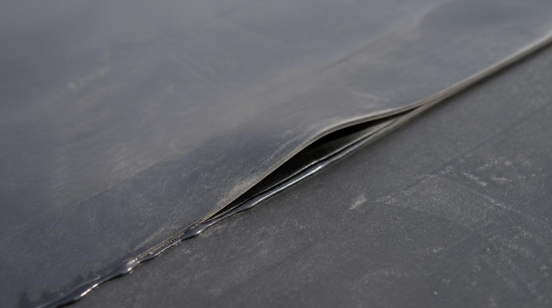 Open lap seam on a black EPDM rubber roof membrane