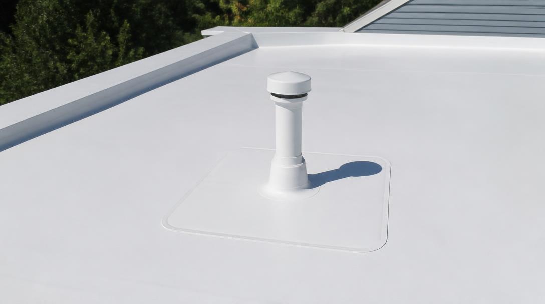 White TPO membrane roof with a heat welded patch around a vent penetration